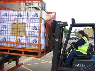 forklift driver removing aquarium stock from large truck